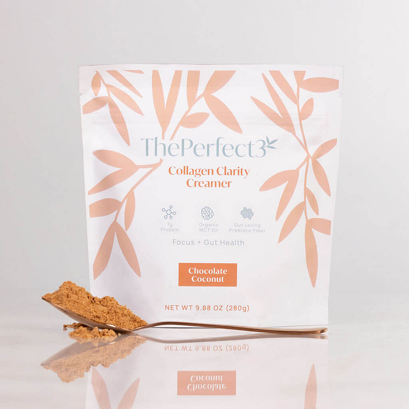 ThePerfect3 Chocolate Coconut Collagen Creamer bag with a spoon of collagen creamer powder in front of it.